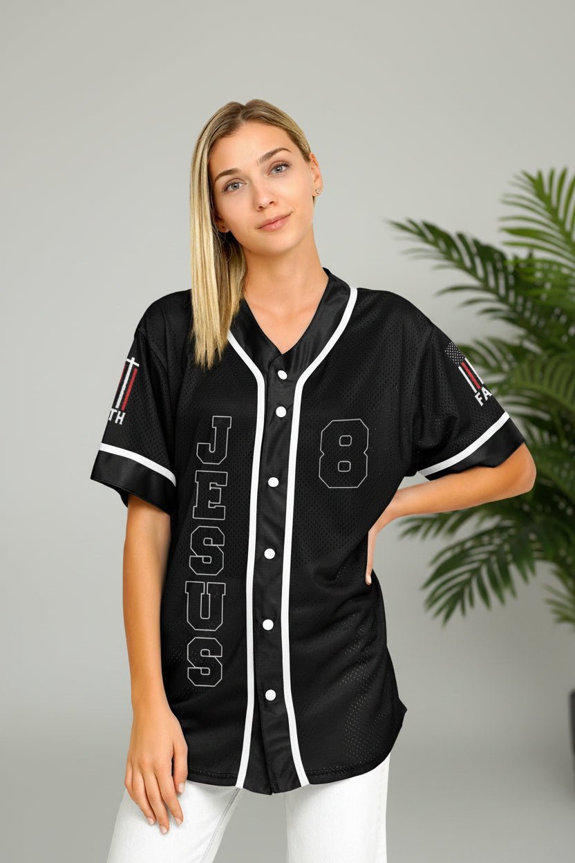 Woman wearing a black baseball jersey with white lettering and numbers on a plain background